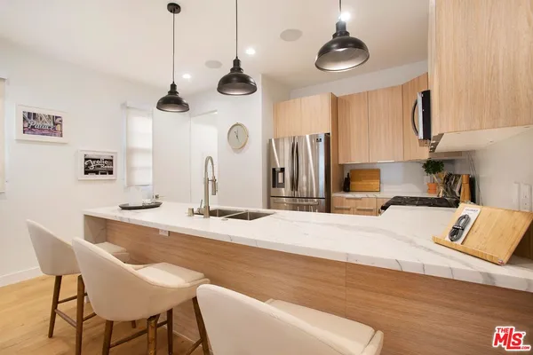 a kitchen with stainless steel appliances granite countertop a sink a stove and a wooden floors