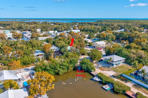 an aerial view of residential houses with outdoor space and ocean view