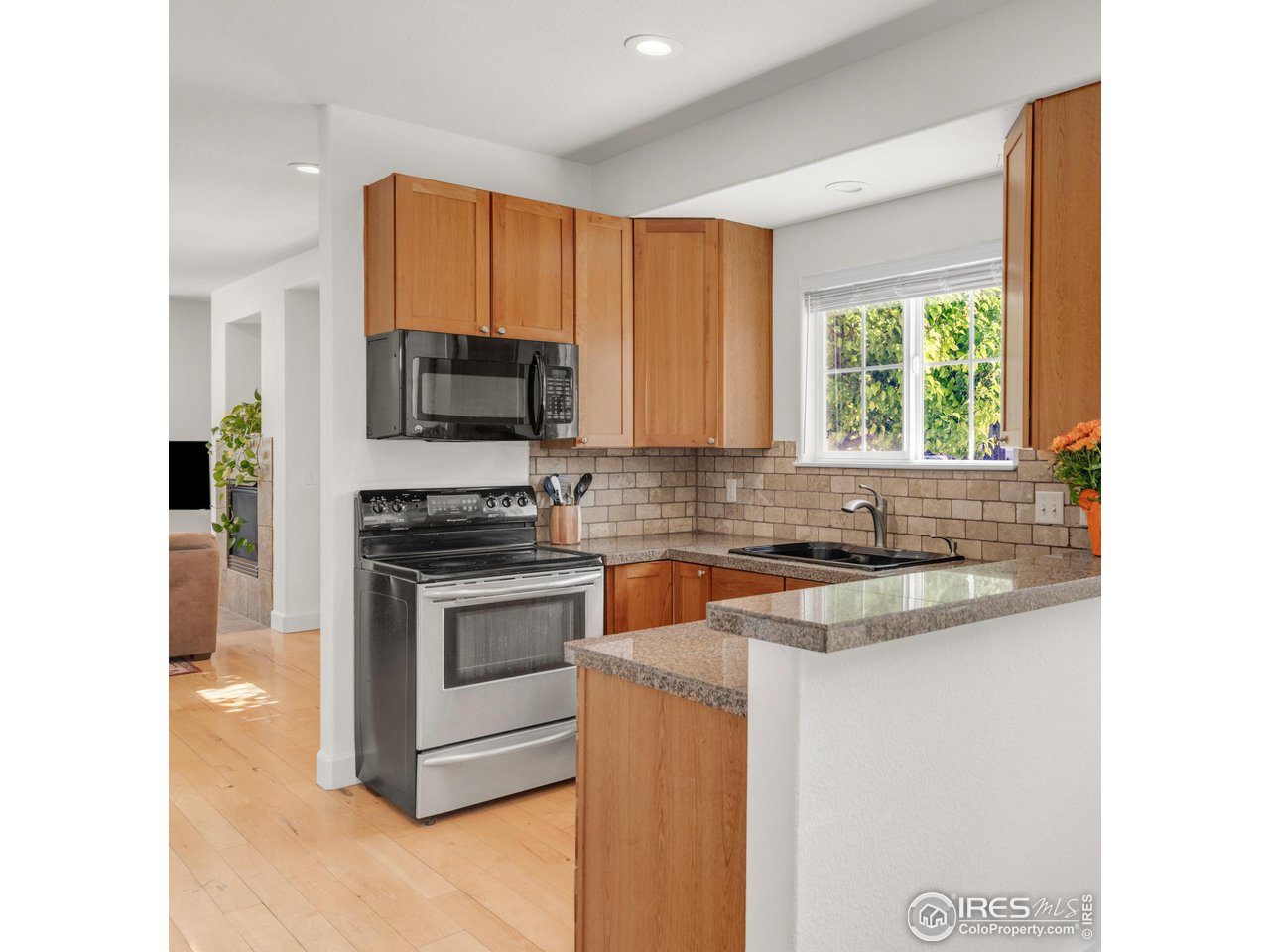 4232 Riley Drive Longmont, CO 80503 - Photo 15 of 35 a kitchen with stainless steel appliances granite countertop a stove a sink and a microwave