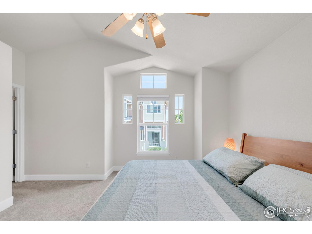 4232 Riley Drive Longmont, CO 80503 - Photo 21 of 35 a bedroom with a large bed and a chandelier