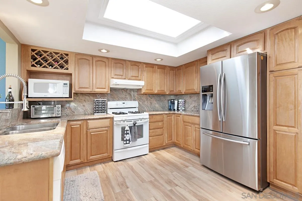 9433 Doheny Road Santee, CA 92071 - Photo 1 of 31 a kitchen with granite countertop stainless steel appliances a refrigerator sink and microwave