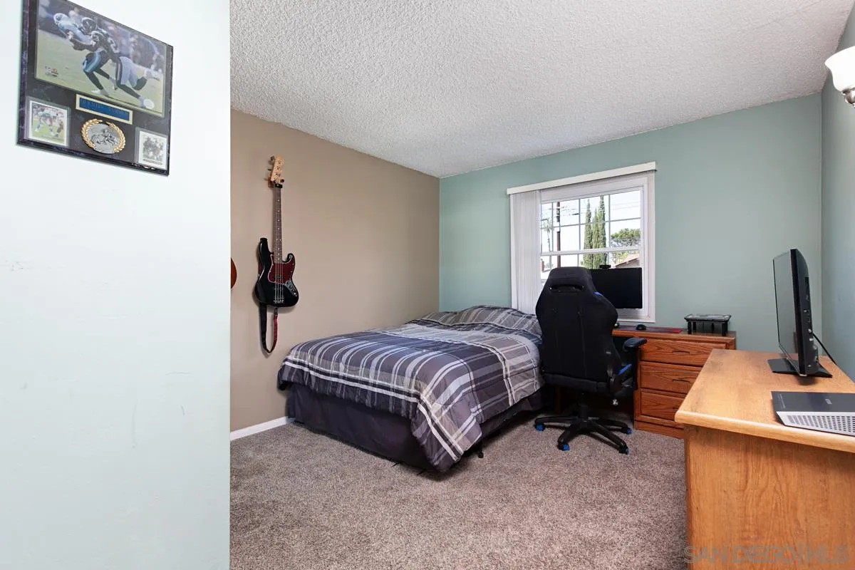 9433 Doheny Road Santee, CA 92071 - Photo 22 of 31 a spacious bedroom with a bed and a desk