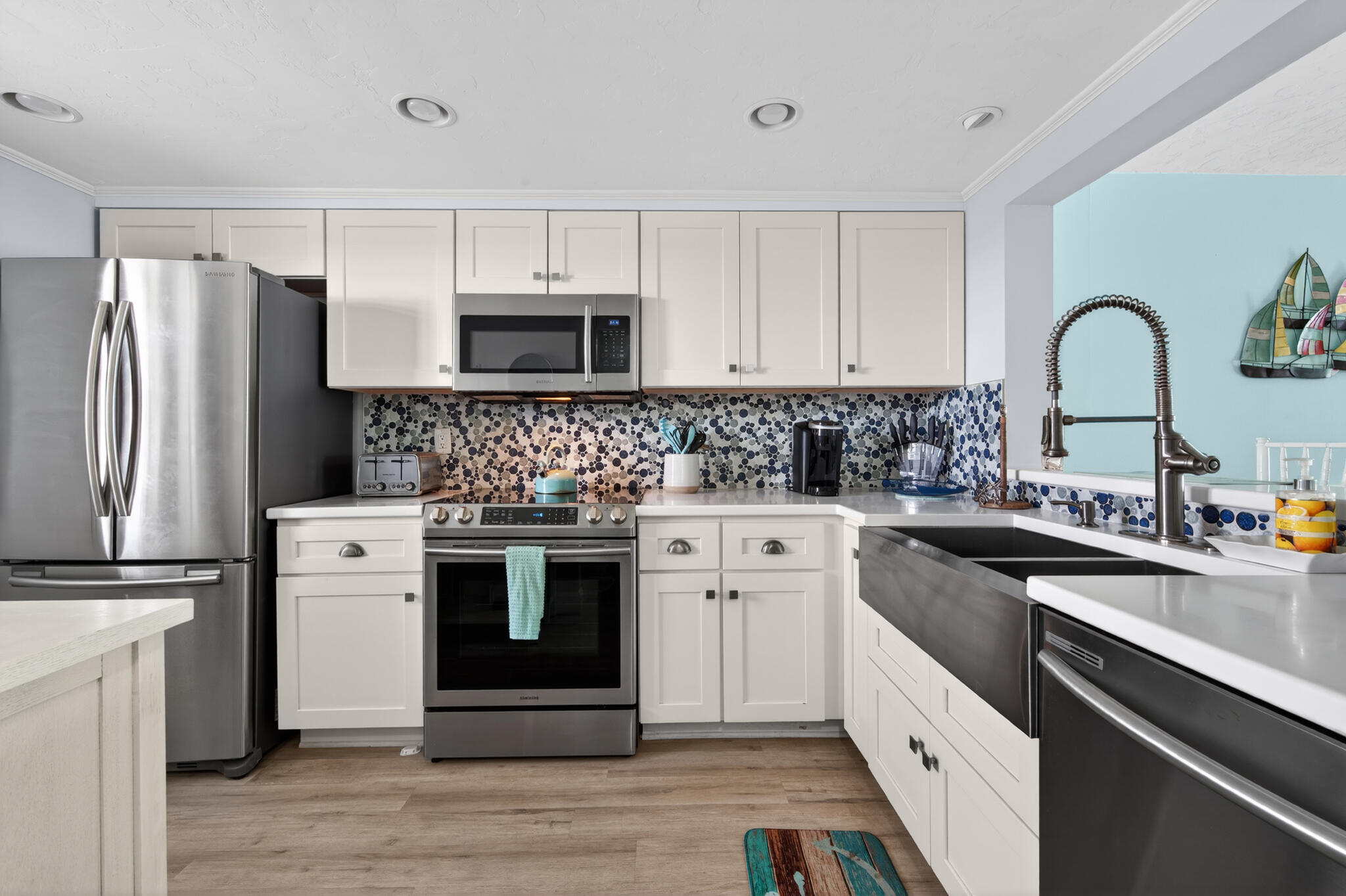 4250 North Hwy A1A, Unit 1007 Fort Pierce, FL 34949 - Photo 13 of 24 a kitchen with white cabinets stainless steel appliances and sink