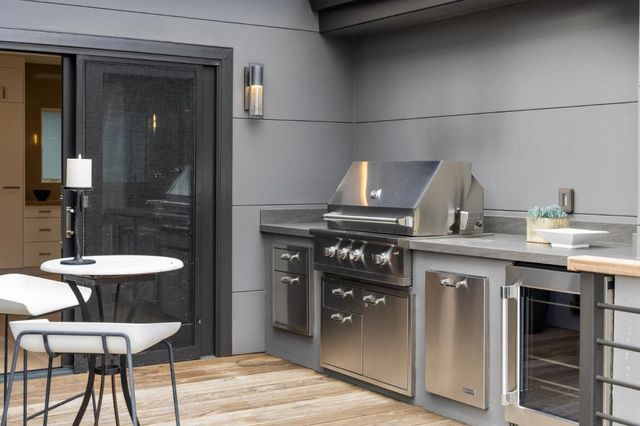 a kitchen with a stove a refrigerator and a dining table with wooden floor