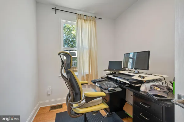 a view of a workspace with furniture and a window