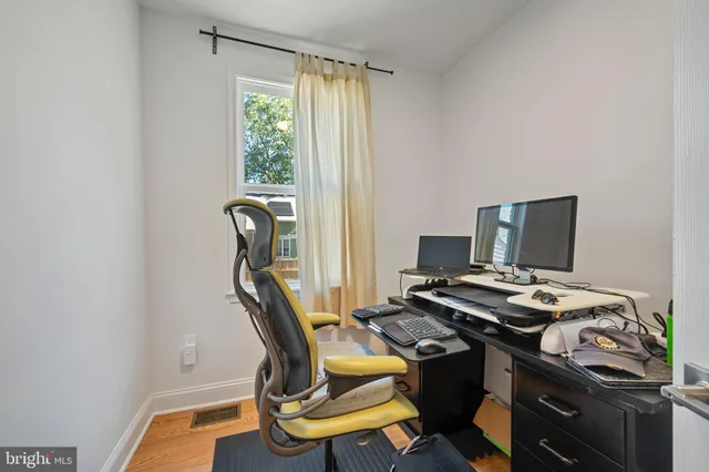 a view of a workspace with furniture and a window