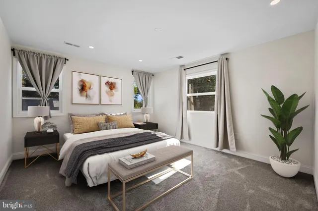 a bedroom with a large bed and a potted plant