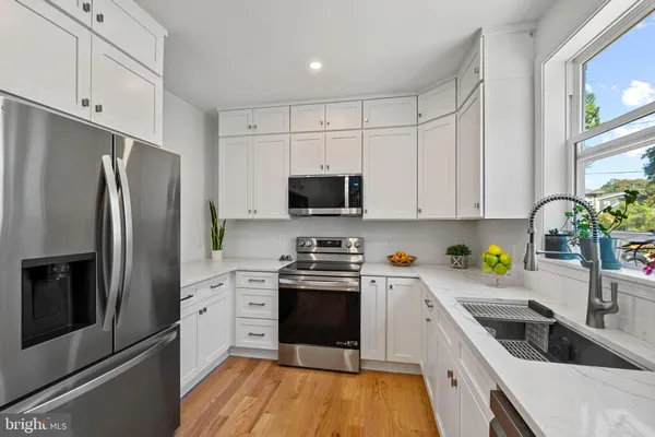 a kitchen with a sink a counter space appliances and cabinets