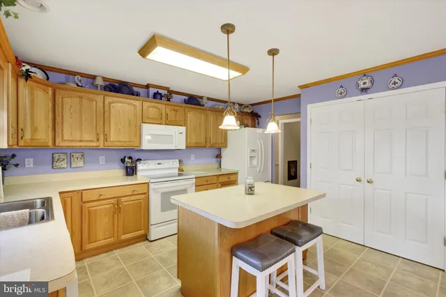 a kitchen with a sink a stove a refrigerator and white cabinets