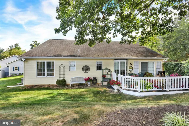 a view of a house with a big yard and large trees