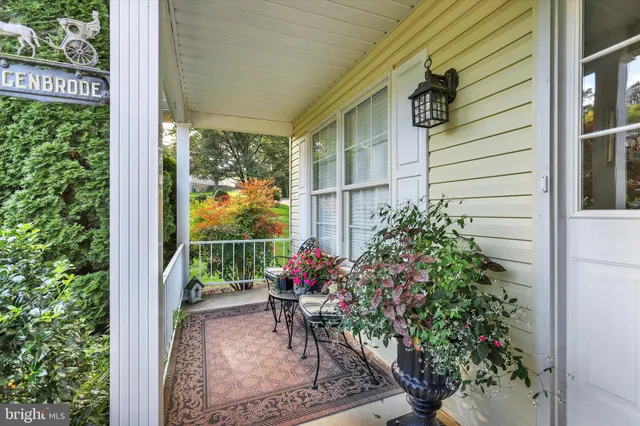 a view of a porch with chairs and potted plants