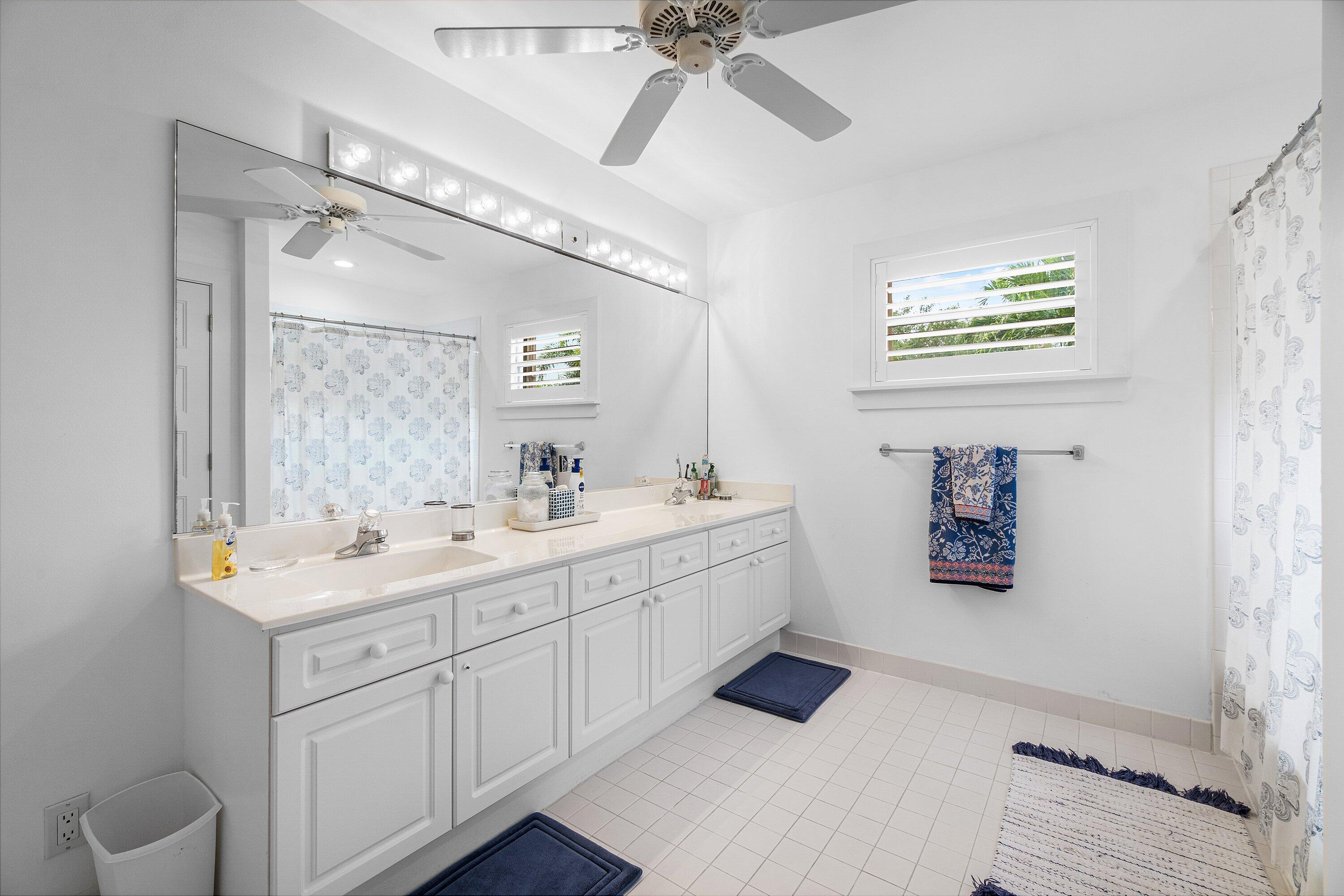 2404 Northwest 67th Street Boca Raton, FL 33496 - Photo 26 of 74 a spacious bathroom with a double vanity sink a mirror and a bathtub