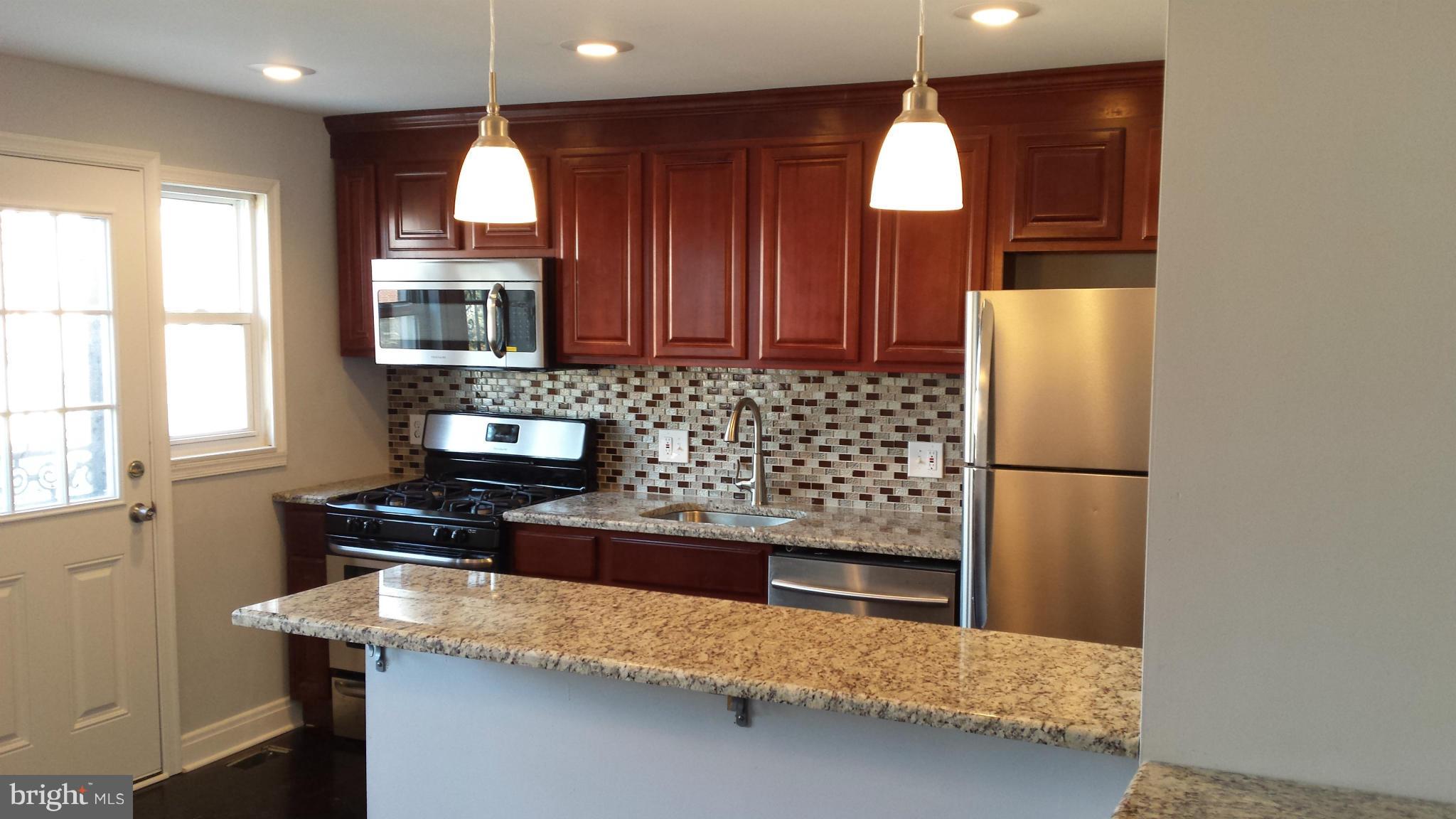 1111 Wicklow Road Baltimore, MD 21229 - Photo 2 of 15 a kitchen with granite countertop cabinets and window
