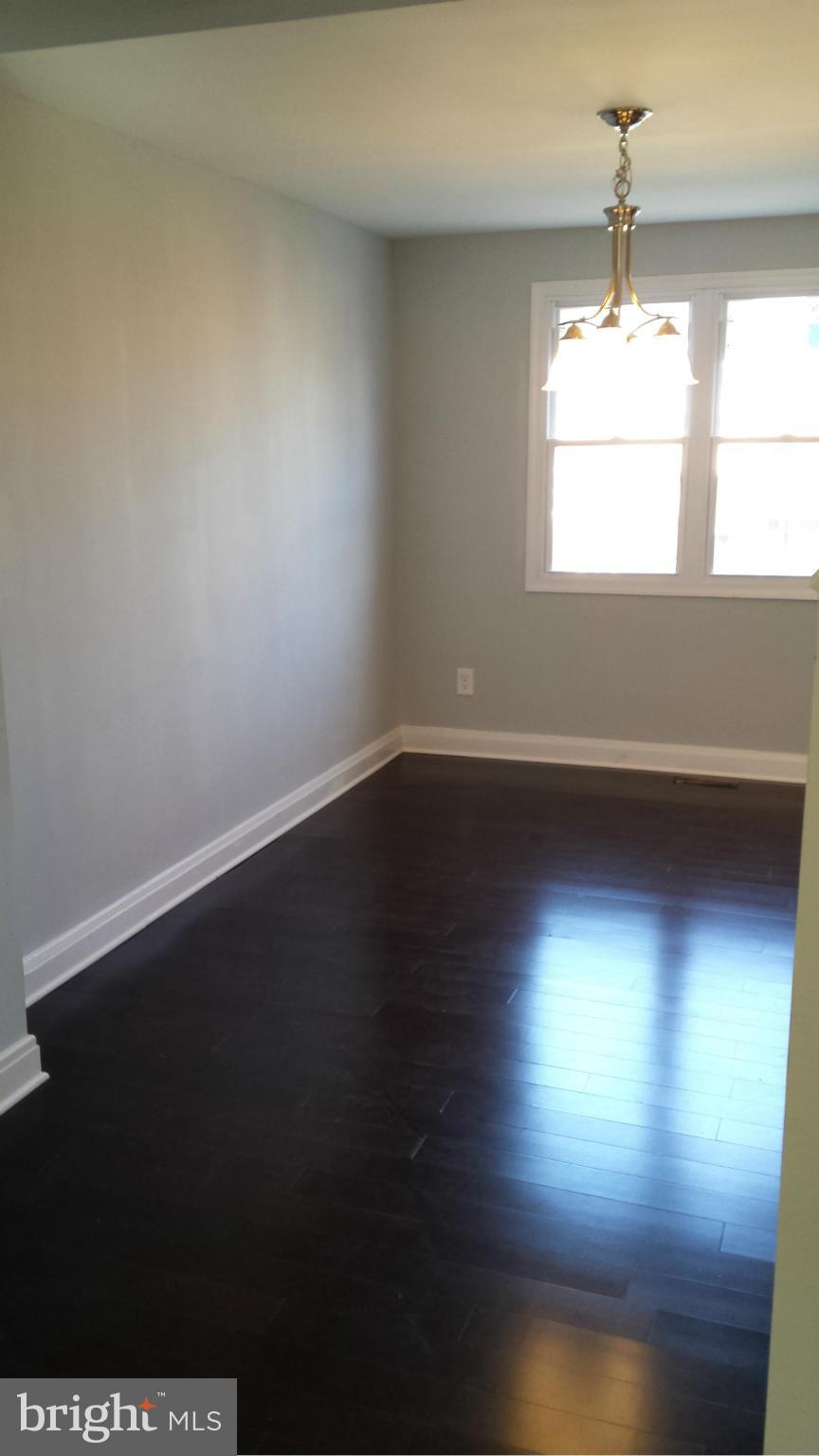 1111 Wicklow Road Baltimore, MD 21229 - Photo 5 of 15 an empty room with wooden floor and windows