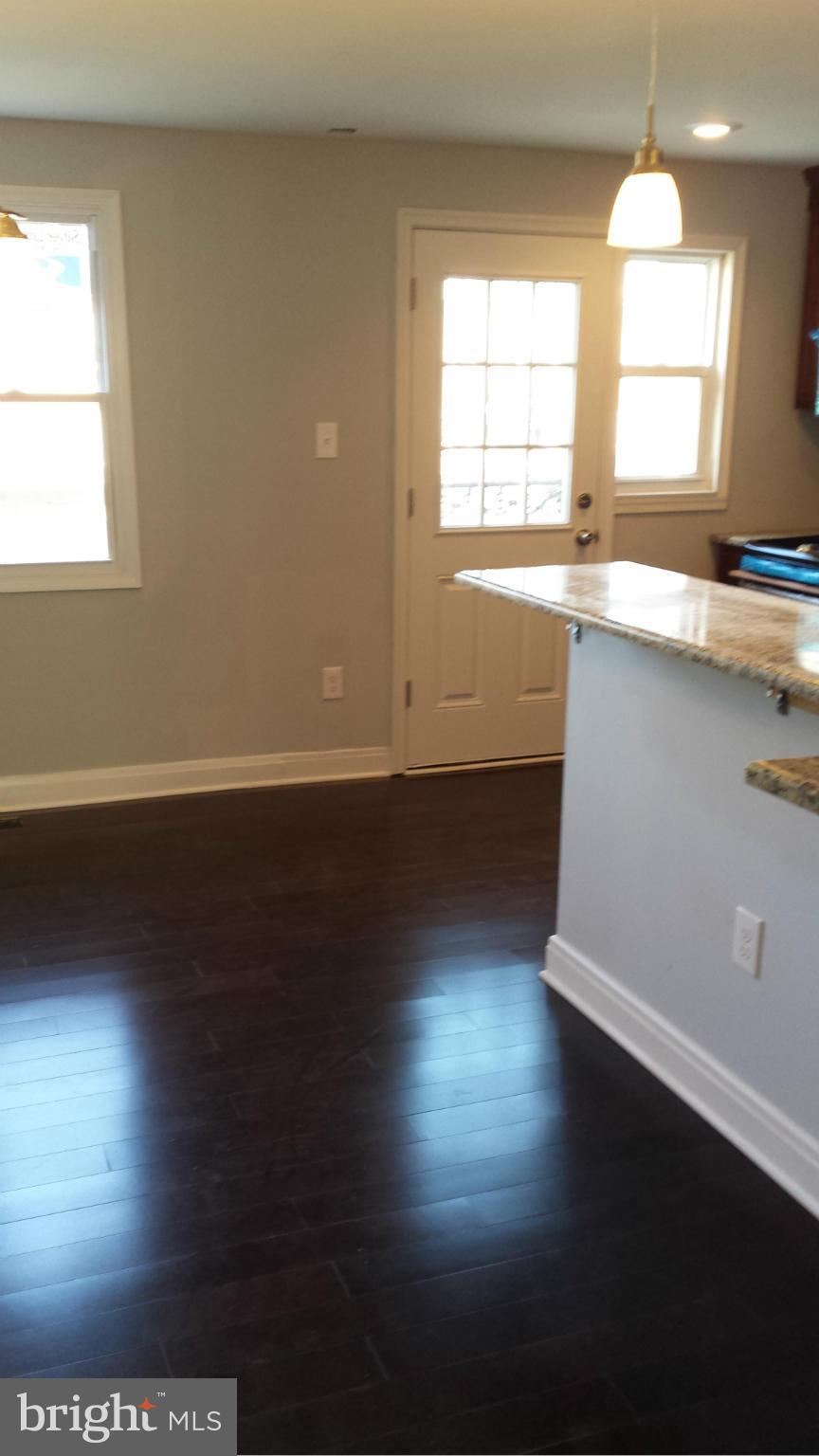 1111 Wicklow Road Baltimore, MD 21229 - Photo 6 of 15 an empty room with wooden floor and windows