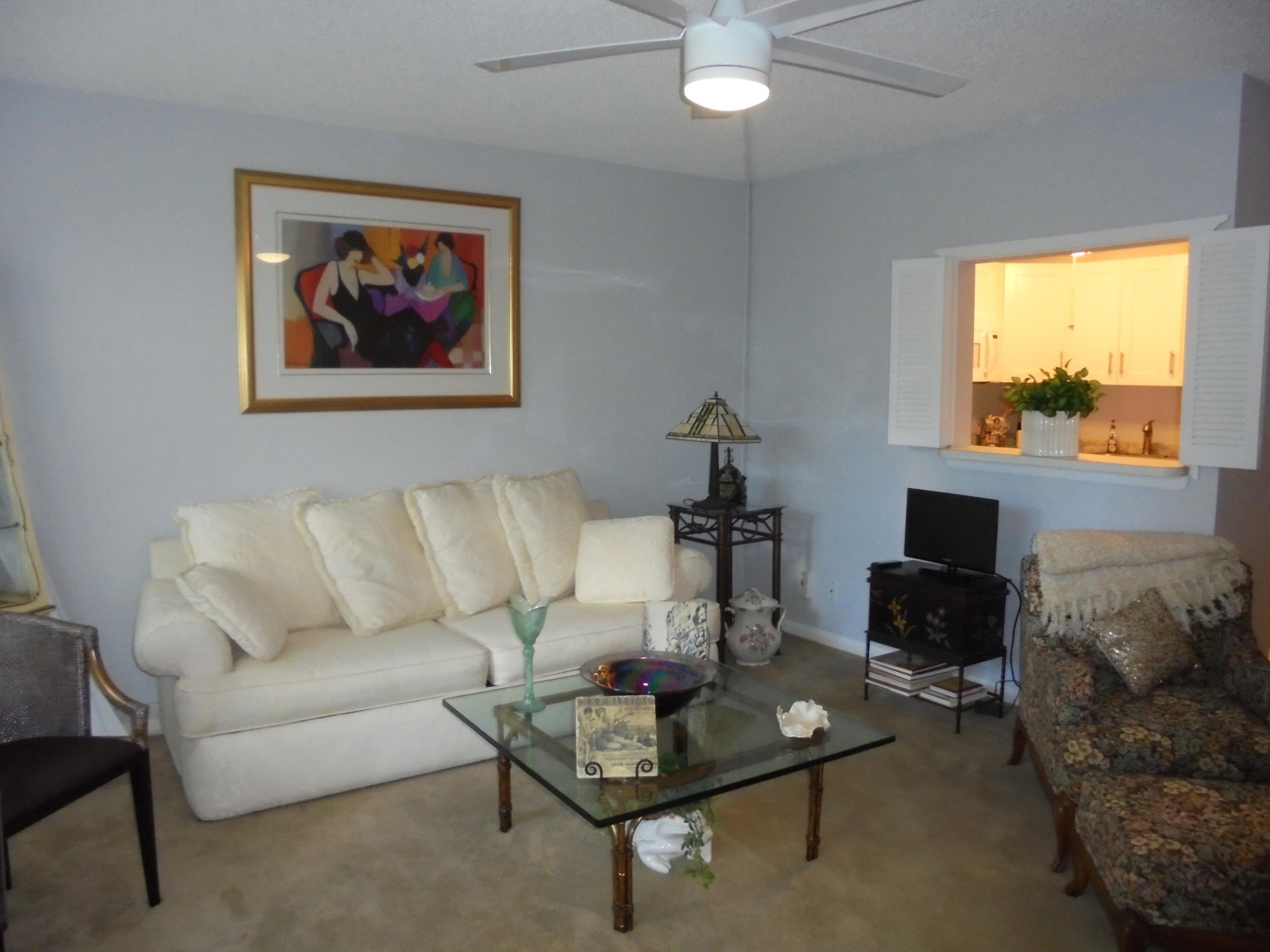 3 Dorset A Boca Raton, FL 33434 - Photo 2 of 18 a living room with furniture a flat screen tv and a fireplace