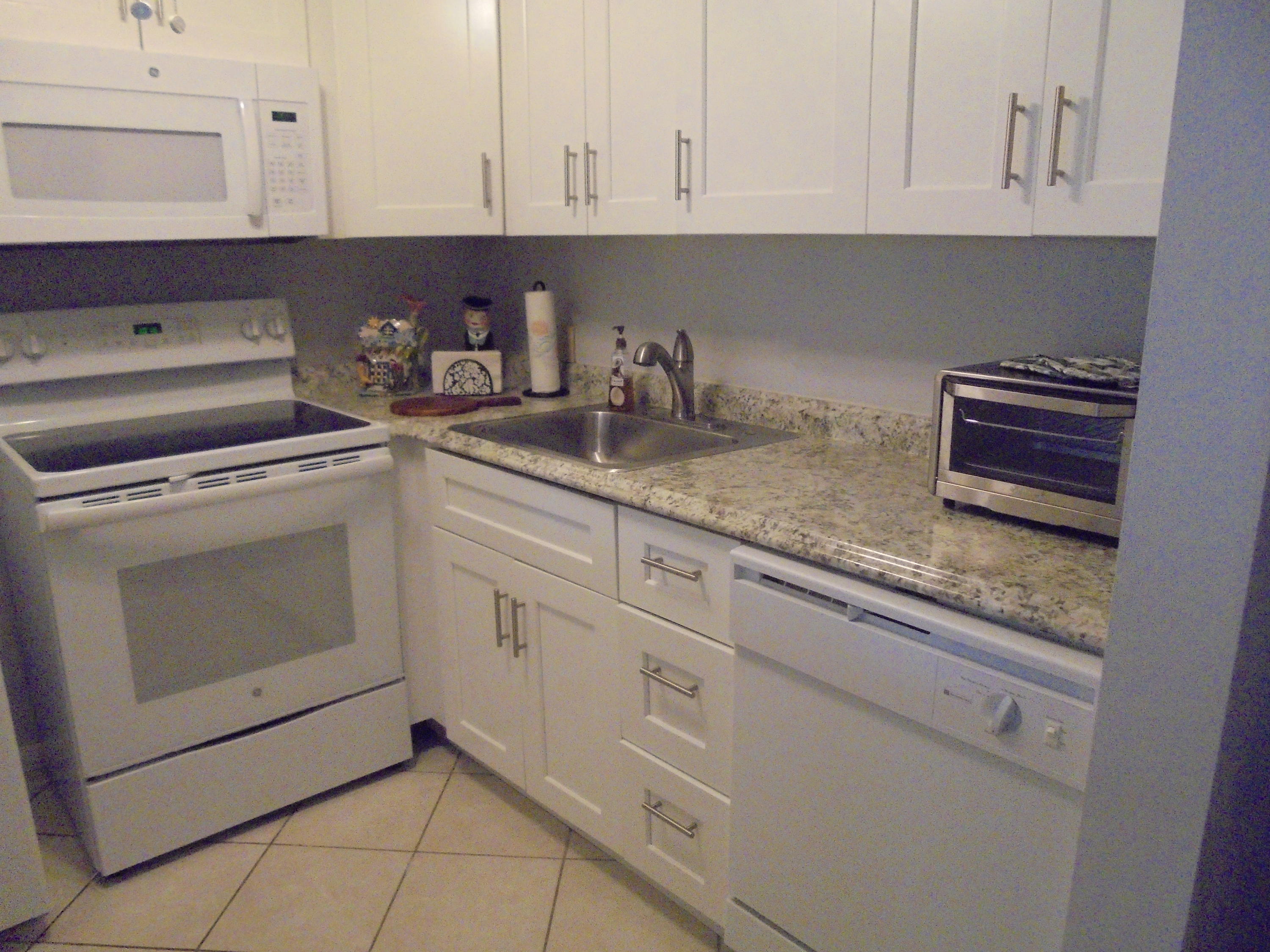 3 Dorset A Boca Raton, FL 33434 - Photo 8 of 18 a kitchen with granite countertop white cabinets and white appliances