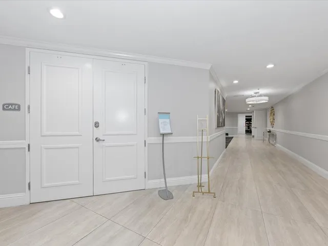 a view of a hallway with entryway and chandelier