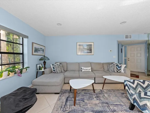 a living room with furniture and a potted plant