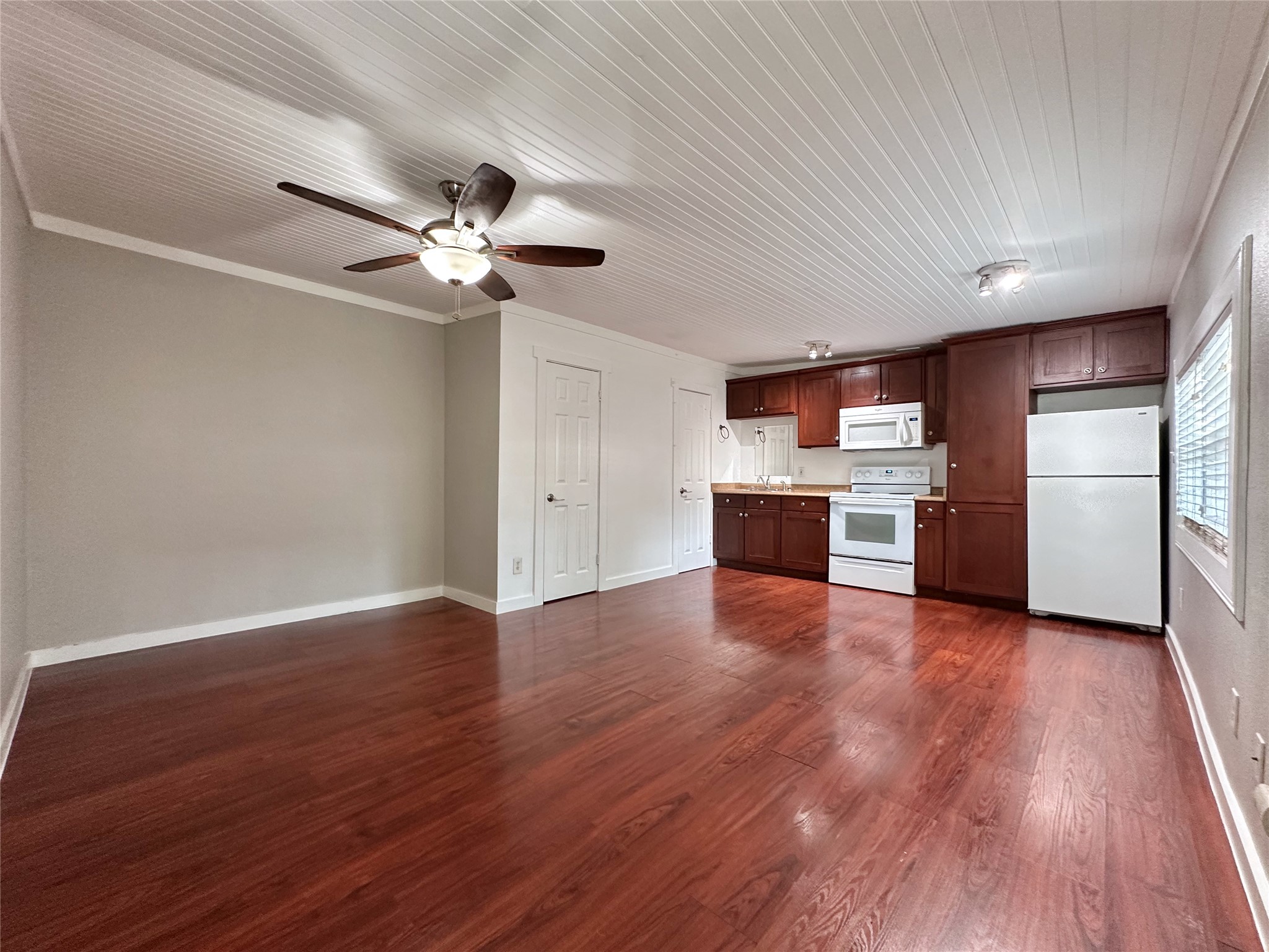 2103 East 16th Street, Unit ANNEX Austin, TX 78702 - Photo 2 of 23 a view of a kitchen with a dishwasher a kitchen wooden floor and a ceiling fan