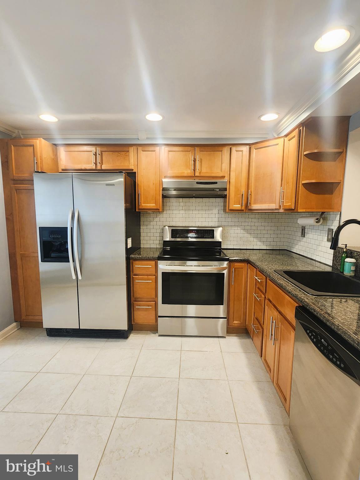 9533 Quarry Bridge Court Columbia, MD 21046 - Photo 4 of 17 a kitchen with stainless steel appliances granite countertop a stove a sink and a refrigerator