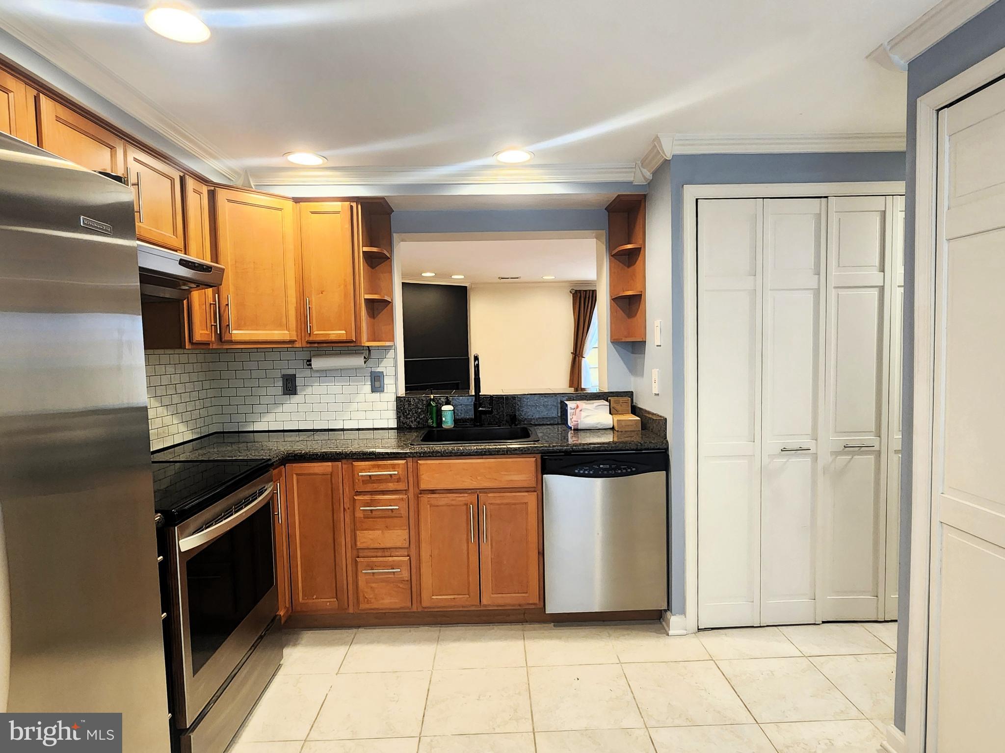 9533 Quarry Bridge Court Columbia, MD 21046 - Photo 6 of 17 a kitchen with stainless steel appliances granite countertop a stove a sink and a refrigerator
