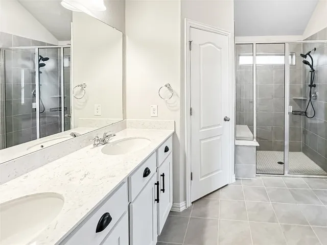 a bathroom with a granite countertop sink mirror and shower