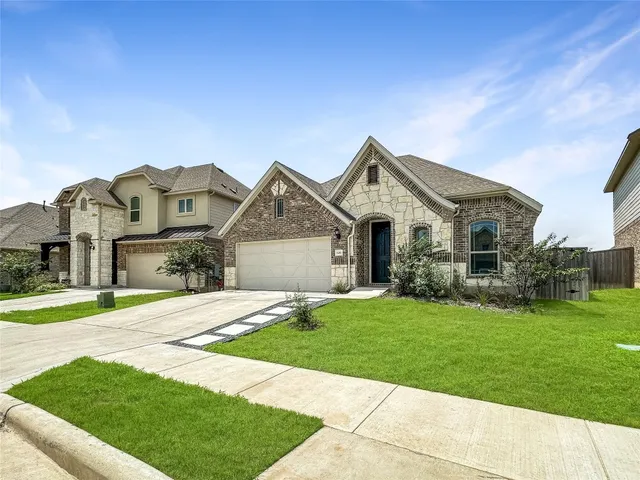 a front view of a house with a garden and yard