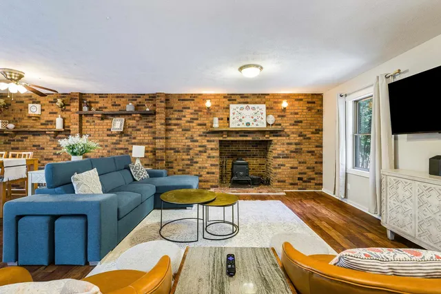a living room with furniture a flat screen tv and a fireplace