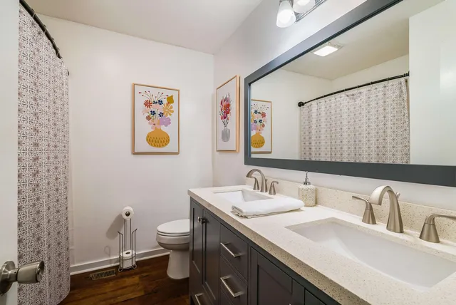 a bathroom with a granite countertop sink toilet and a mirror