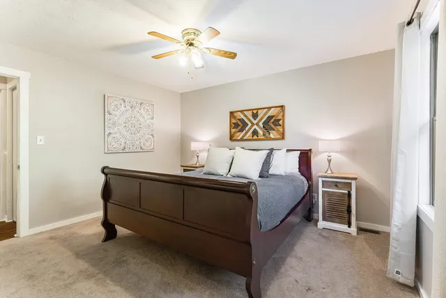 a bedroom with a bed and a flat tv screen on dresser