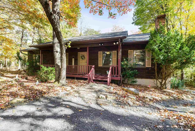 a view of a house with a large tree and a yard