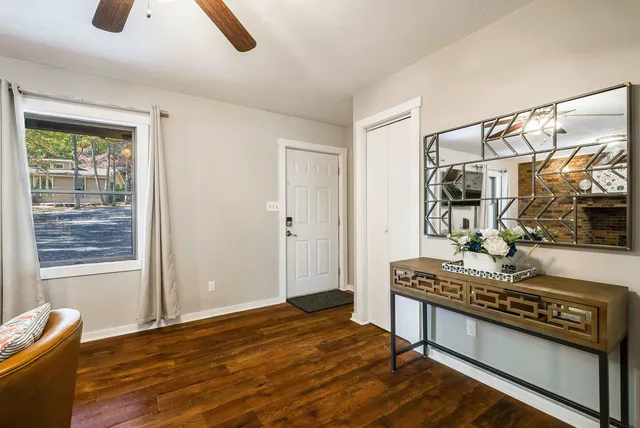 a living room with stainless steel appliances furniture a rug and a window