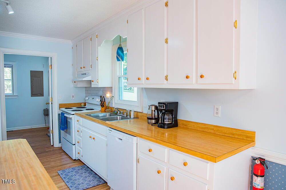 850 Lewis Winstead Lp Road Roxboro, NC 27574 - Photo 20 of 72 a kitchen with stainless steel appliances granite countertop a sink and dishwasher with white cabinets