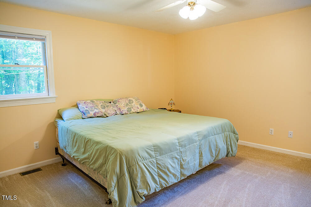 850 Lewis Winstead Lp Road Roxboro, NC 27574 - Photo 28 of 72 a bedroom with a bed and a chandelier