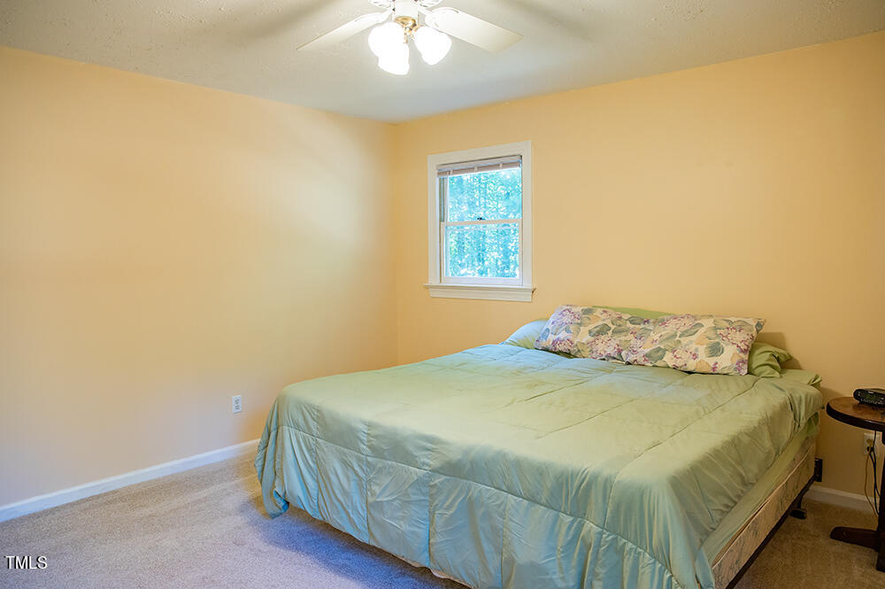 850 Lewis Winstead Lp Road Roxboro, NC 27574 - Photo 30 of 72 a bedroom with a bed and a chandelier