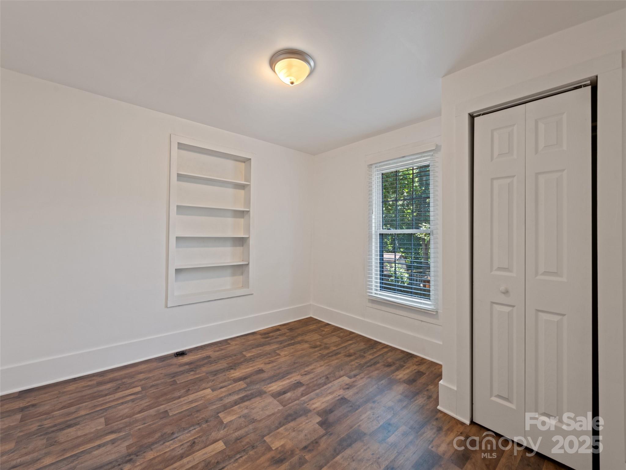 468 Deaverview Road Asheville, NC 28806 - Photo 21 of 26 an empty room with wooden floor closet and windows