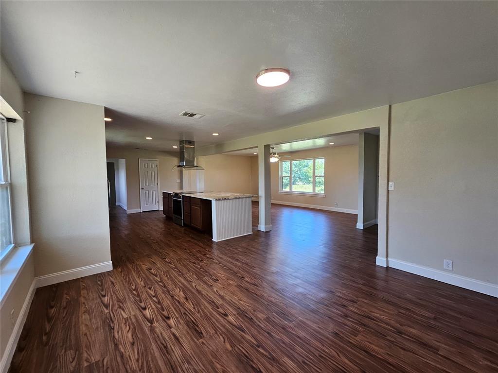 2100 Farm To Market 4 Cleburne, TX 76031 - Photo 15 of 16 an empty room with wooden floor and kitchen view