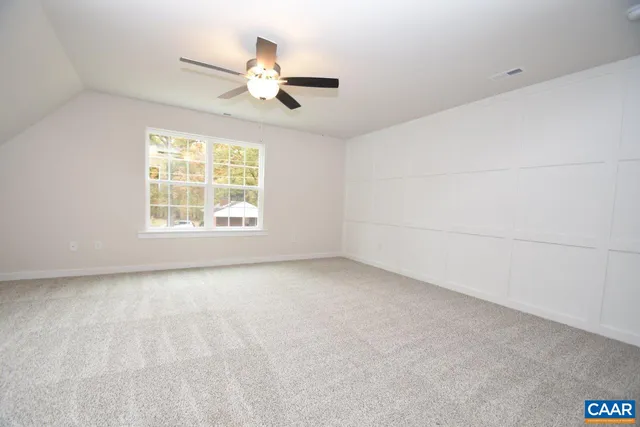 an empty room with a window and a ceiling fan