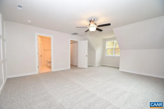 an empty room with windows and ceiling fan