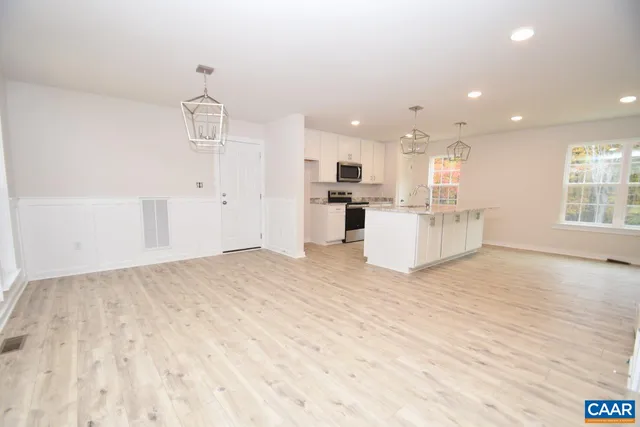 a view of a kitchen with kitchen island a sink wooden floor and counter top space
