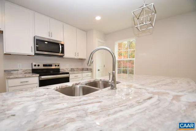 a kitchen with granite countertop a sink stainless steel appliances and cabinets