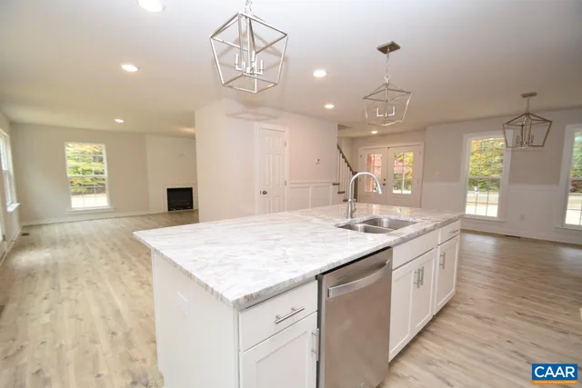 a large kitchen with kitchen island a sink stainless steel appliances and chandelier