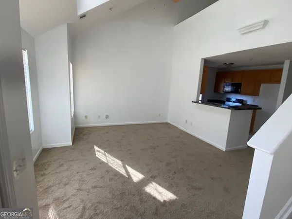a view of a hallway to a room with a window