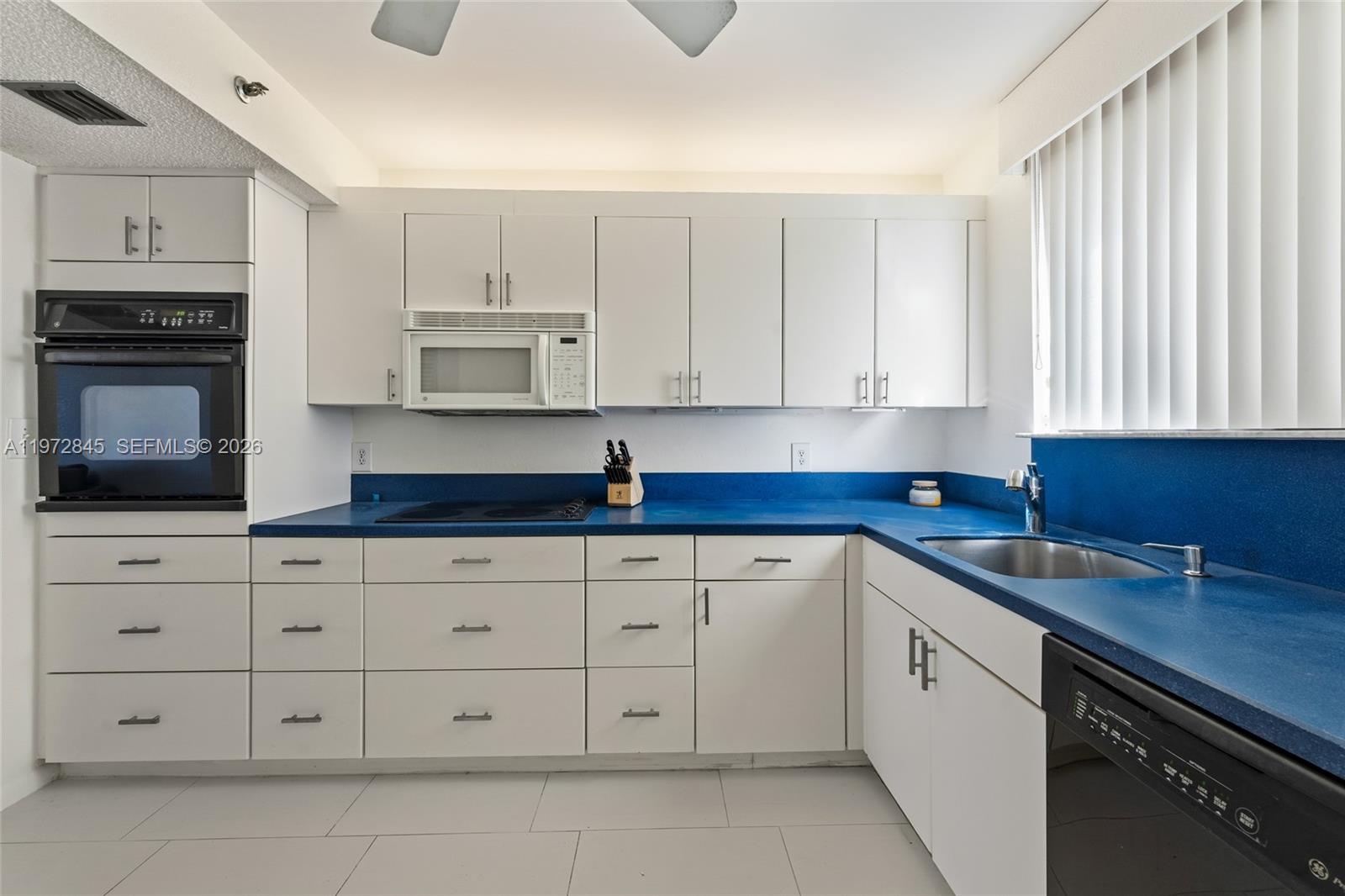 300 Ocean Trail Way, Unit 201 Jupiter, FL 33477 - Photo 9 of 15 a kitchen with granite countertop white cabinets and stainless steel appliances