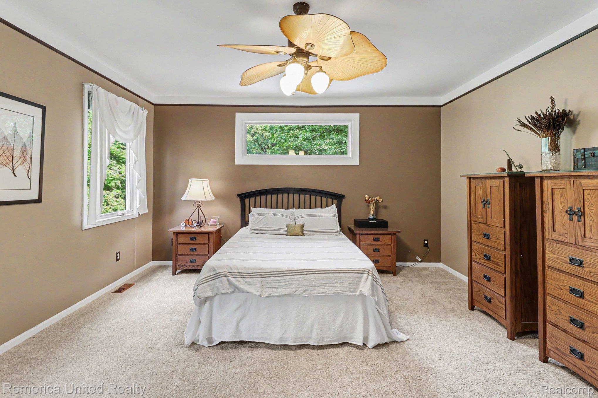 20962 Wasson Road Gregory, MI 48137 - Photo 16 of 39 Carpeted interior space featuring a ceiling fan with light fixture, multiple windows, and two-tone wall paint