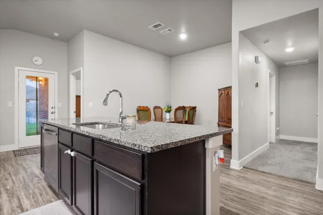 a kitchen with stainless steel appliances granite countertop a sink and a refrigerator