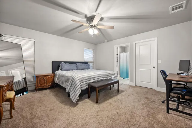 a spacious bedroom with a bed and a chandelier
