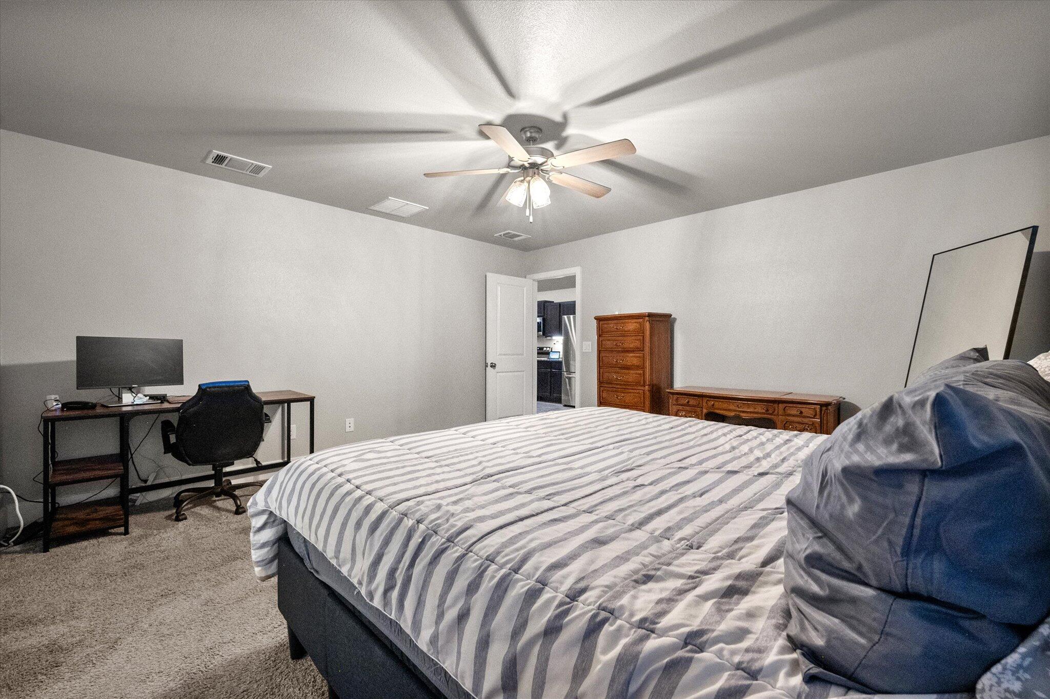 7449 31st Street Lubbock, TX 79407 - Photo 15 of 23 a bedroom with a bed and a chandelier