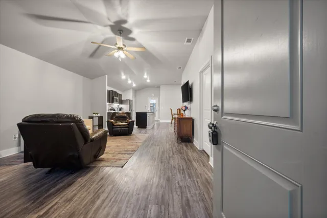 a living room with furniture and a wooden floor